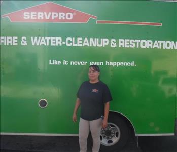 Employee standing in front of a SERVPRO green truck.