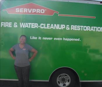 Employee standing in front of a SERVPRO green truck.