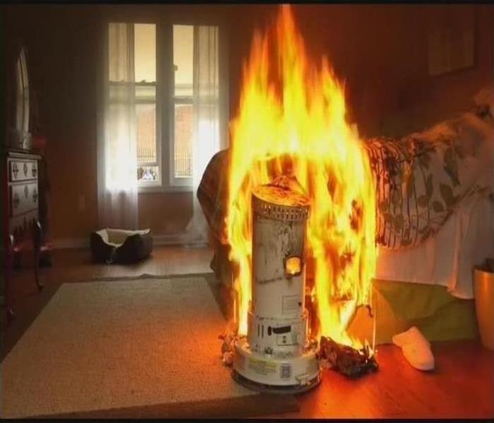 Space heater on fire in a bedroom.