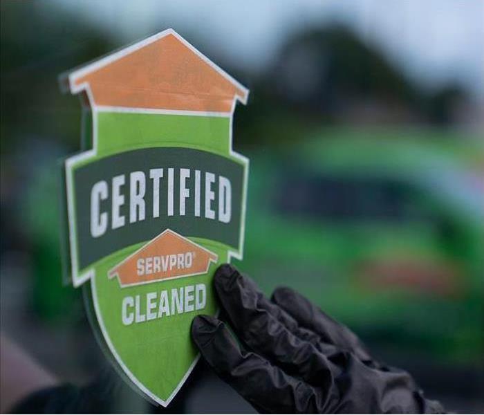 Certified: SERVPRO Cleaned sticker being placed on a window.