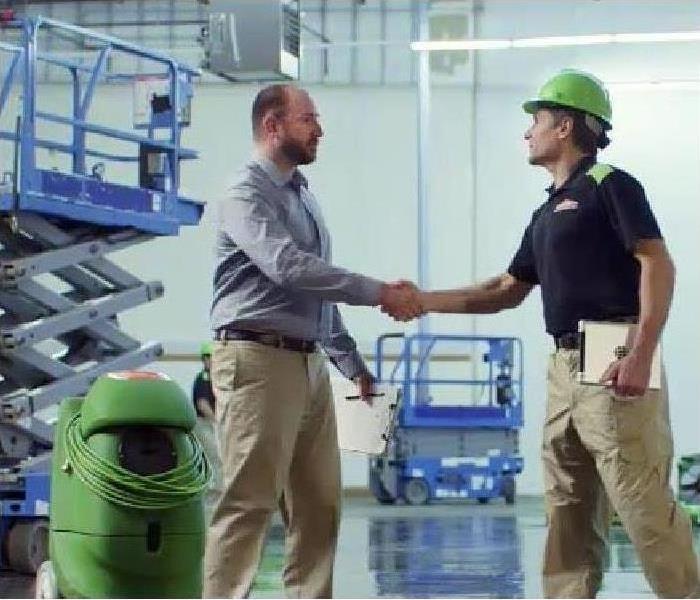 Two men shaking hands in a construction enviroment.  