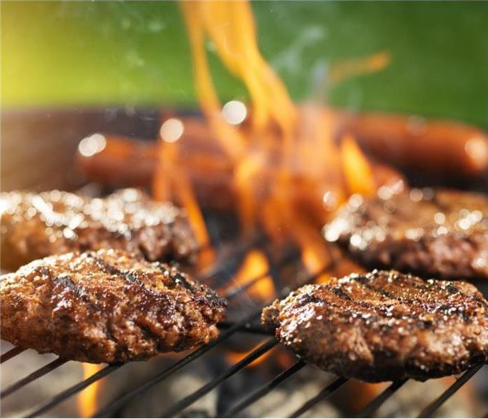 Burgers being charbroiled on a grill. 