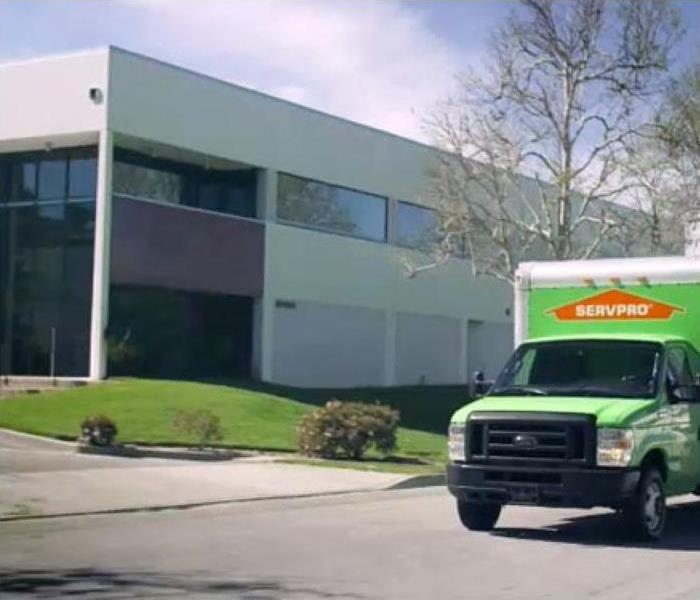 SERVPRO truck driving past a commercial building.