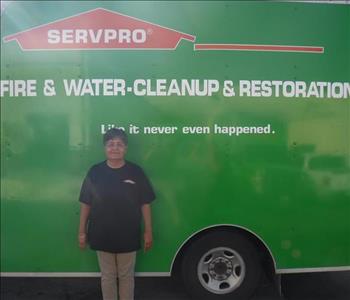 Employee standing in front of a SERVPRO green truck.